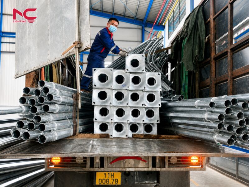 thợ đang đứng trên xe để sắp xếp cột, đèn chuẩn bị bàn giao đến Cao Bằng